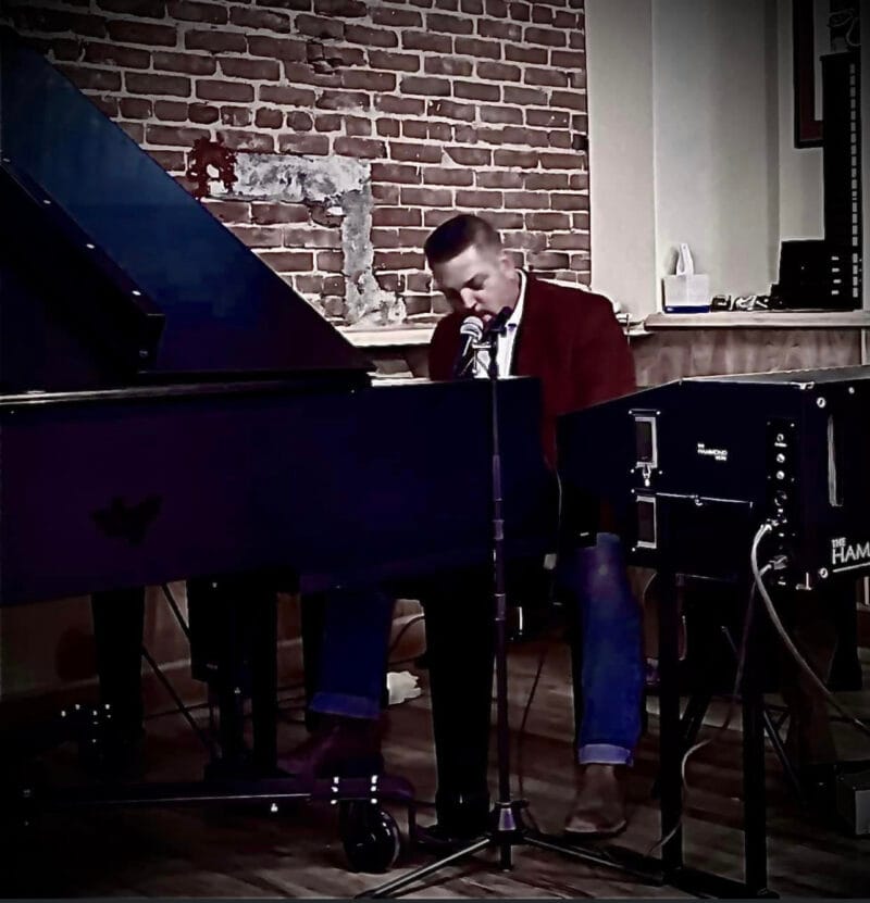 1 Grand Party Pop performer singing and playing one grand piano in an intimate brick-wall venue.